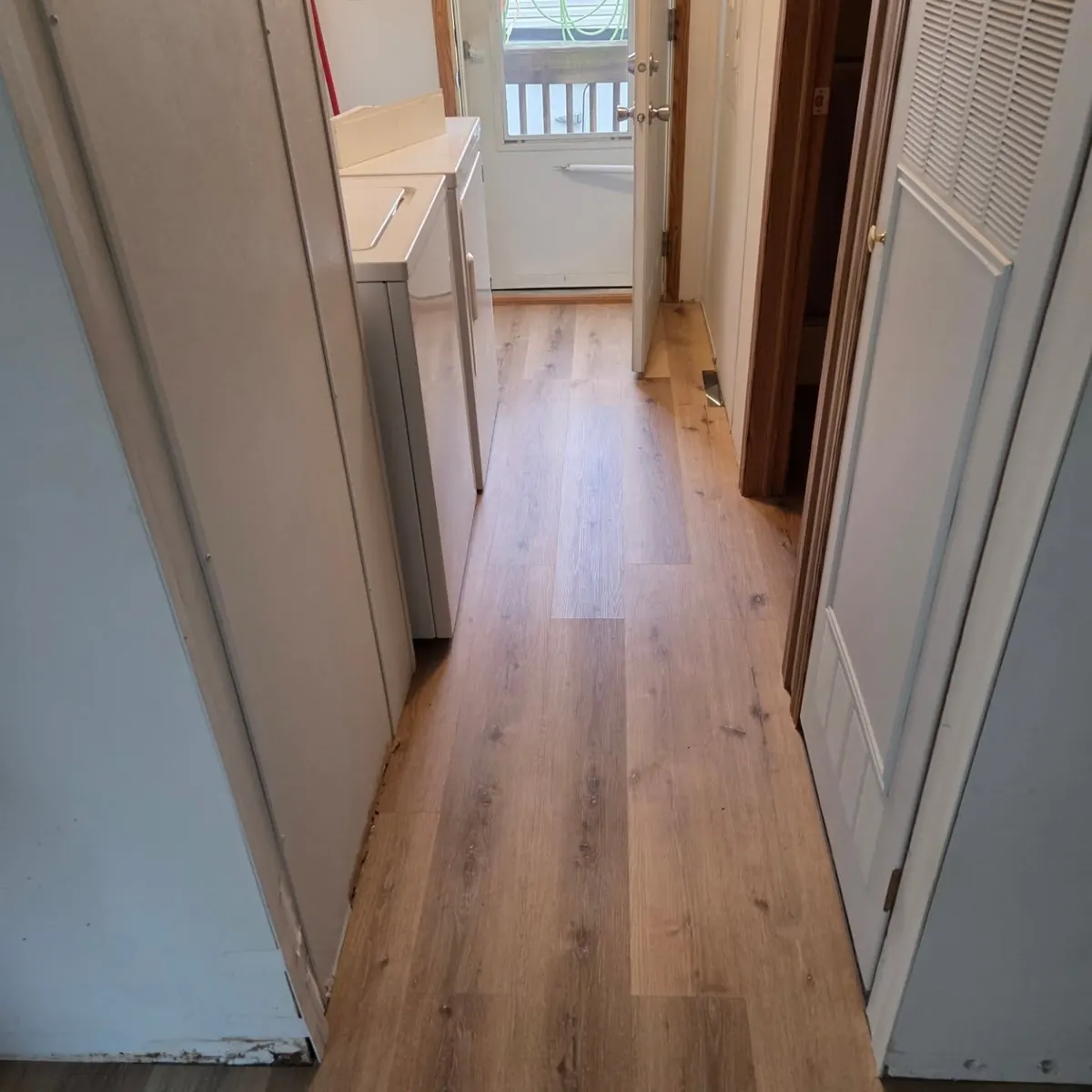 Hallway and laundry area with new wood look flooring installed